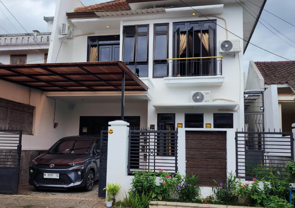 a car parked in front of a house at Neomi Homestay Malang in Wendit