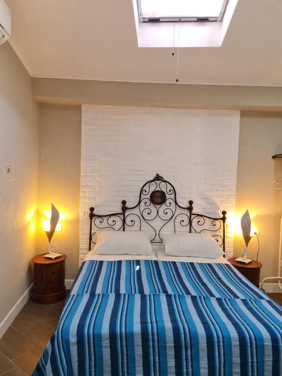 a bedroom with a bed with a blue and white striped bedspread at Eden House in Crotone