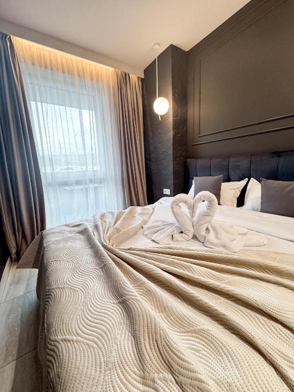 a bedroom with a large bed with two towels on it at Sky Escape - Private Parking, Kingsize Bed & More in Cluj-Napoca