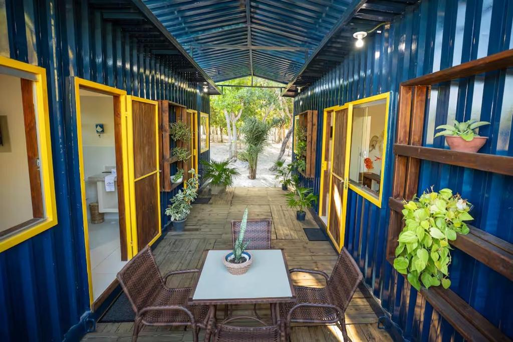 una stanza con tavolo, sedie e parete blu di Container Azul na beira do rio e a poucos metros do mar a Belmonte