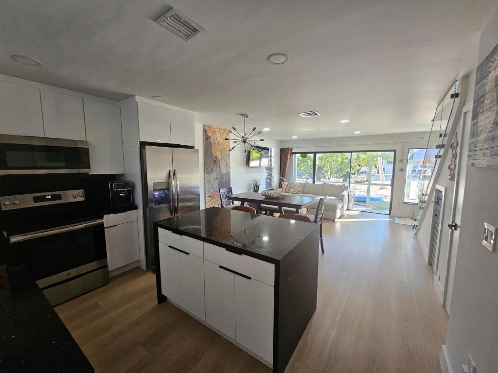 a kitchen and living room with white cabinets and appliances at Day Dreams Key Largo in Key Largo