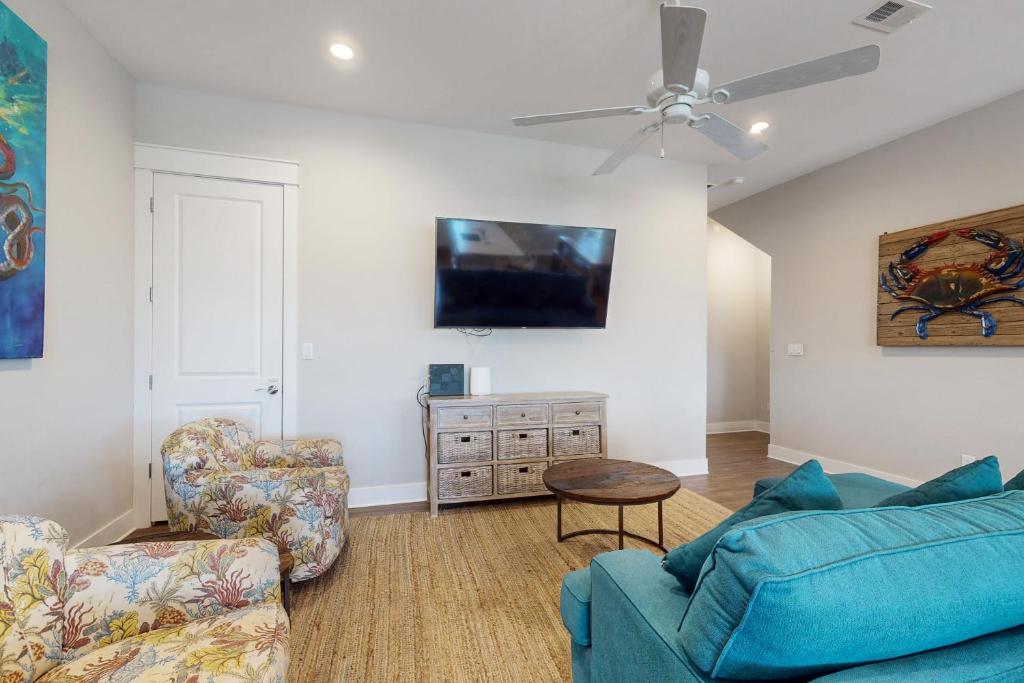 ein Wohnzimmer mit einem blauen Sofa und 2 Stühlen in der Unterkunft The Wild Octopus at Palmilla Beach in Port Aransas