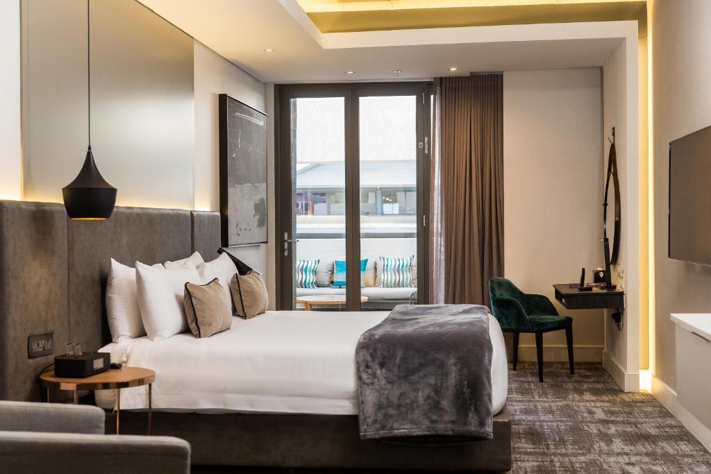 ein Hotelzimmer mit einem Bett und einem Balkon in der Unterkunft The Capital Mirage in Kapstadt