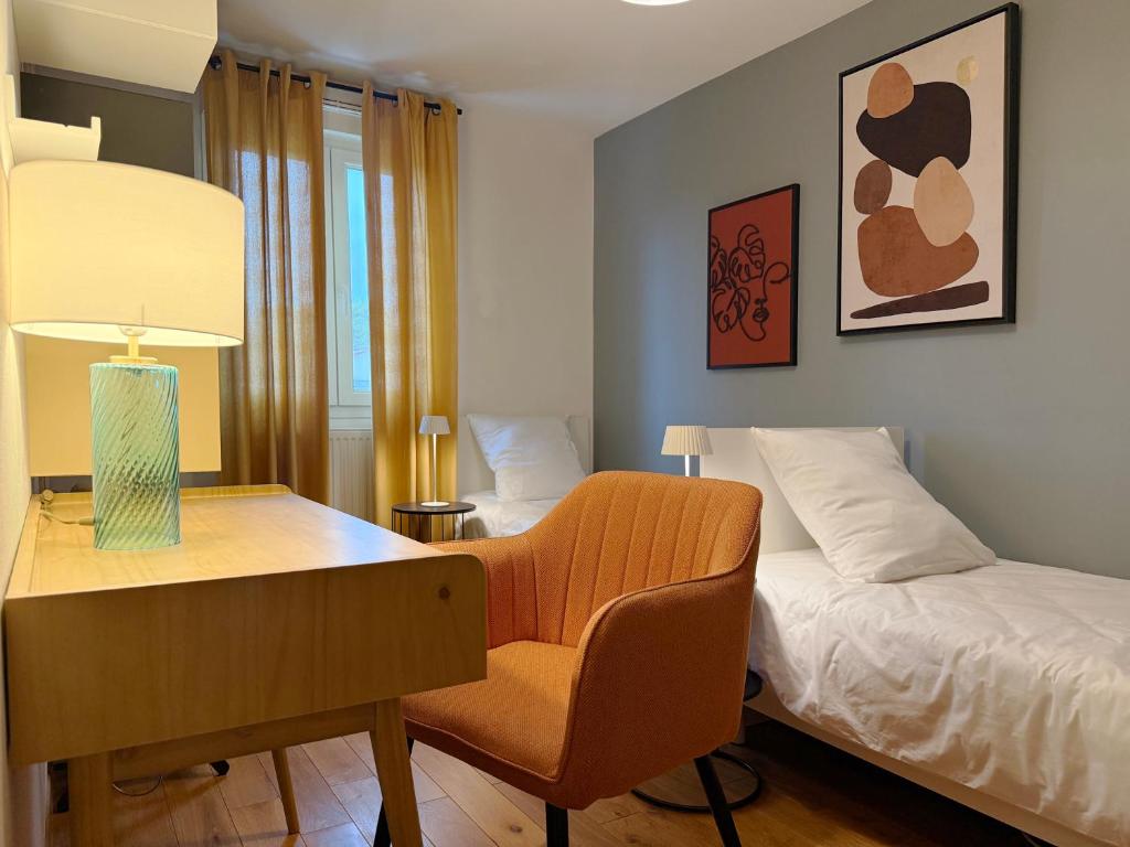 ein Schlafzimmer mit einem Schreibtisch, einem Bett, einem Schreibtisch und einem Stuhl in der Unterkunft La Rose des Vents in Valence