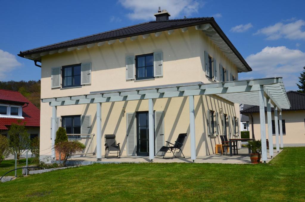a white house with two chairs in the yard at Ferienhaus zur Tulpe, Legoland in Ettenbeuren