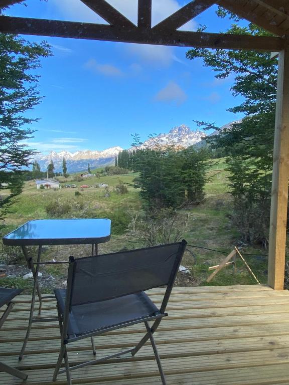 a table and a bench on a deck with a view at Cabaña Huemul in Villa Cerro Castillo
