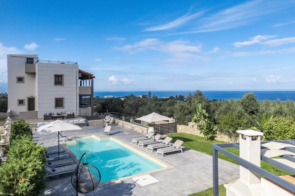 a villa with a swimming pool and the ocean at Villa Aris: A Serene Experience, 3BRs, Pool & Bbq in Magnisía