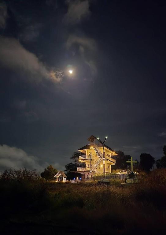a building with the moon in the sky at night at Anemoi Chimes Resort Calvarymount in Idukki