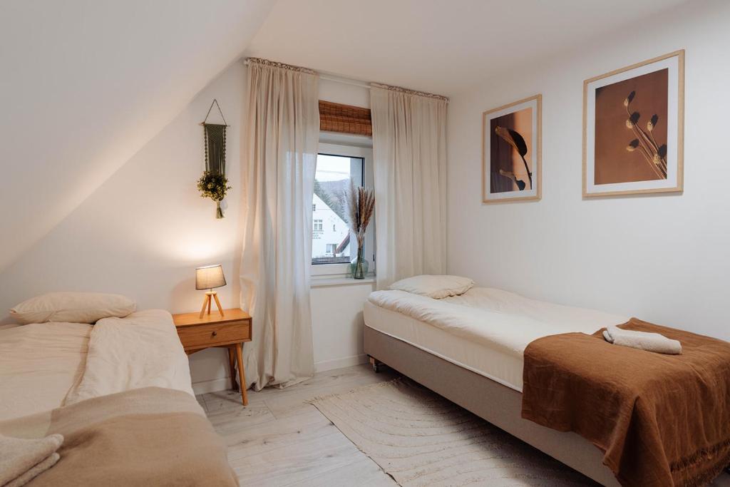 Villa Tapadla في Tąpadła: غرفة نوم بها سريرين ونافذة