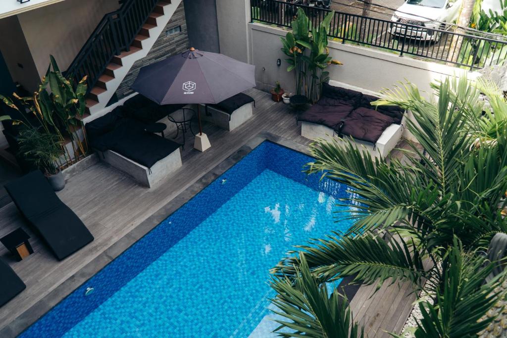 an overhead view of a swimming pool with an umbrella at Hi Cube Hostel in Canggu