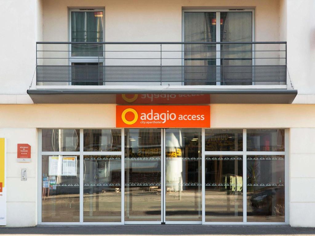una tienda frente a un edificio con una señal de acceso anadobe en Aparthotel Adagio Access Poitiers, en Poitiers