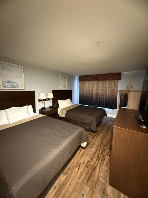 Una habitación de hotel con dos camas y una ventana. en OceanShores Inn, en Ocean Shores