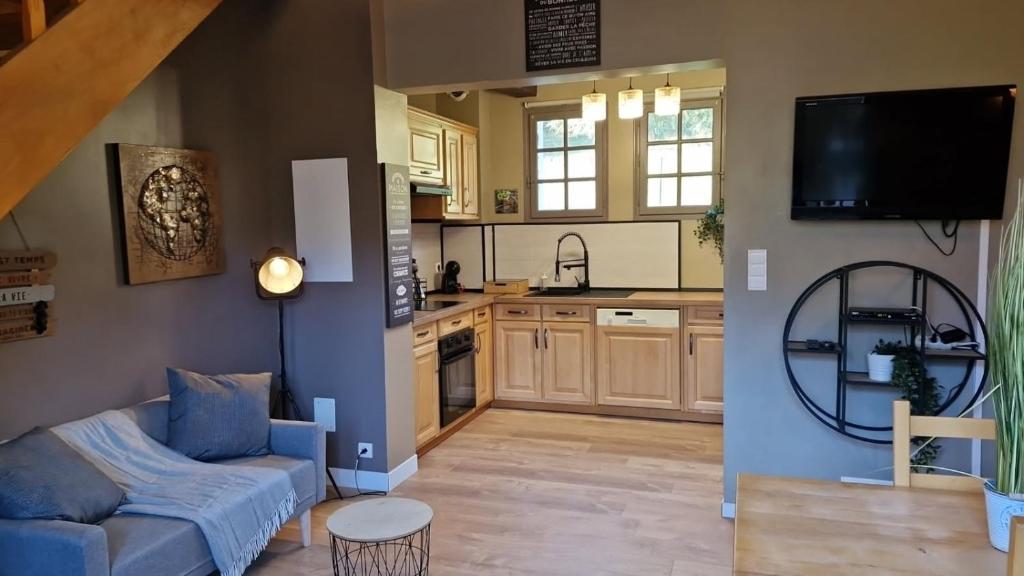 ein Wohnzimmer mit Couch und Küche in der Unterkunft Gite Suyen, Bain nordique, Sauna in Arrens-Marsous