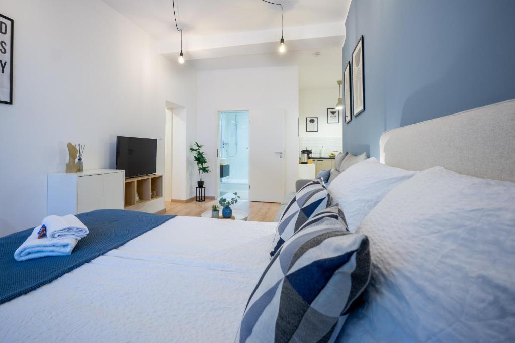 Südstadt-Apartment im Herzen von Paderborn في بادربورن: غرفة نوم بسرير ابيض ومخدات زرقاء وبيضاء