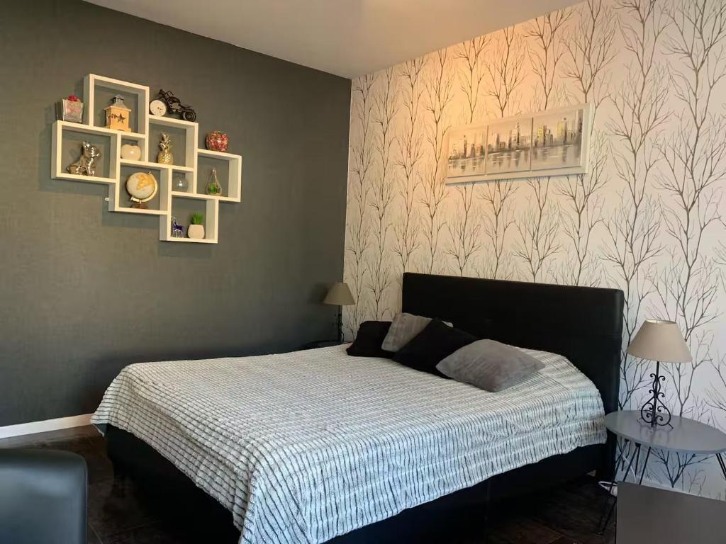 una camera da letto con un letto e alcuni quadri sul muro di beau T1 30 résidence sécurisée proche centre ville parking privé wifi a La Celle-sous-Gouzon