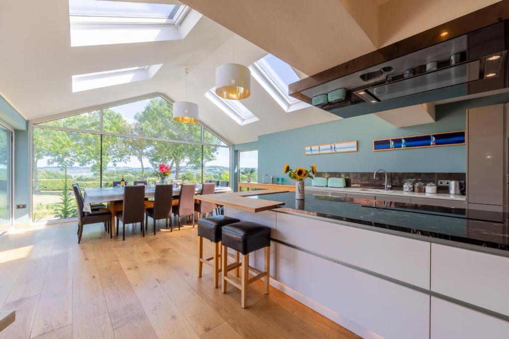 a kitchen with a dining room with a table and chairs at Lakeside in Compton Martin