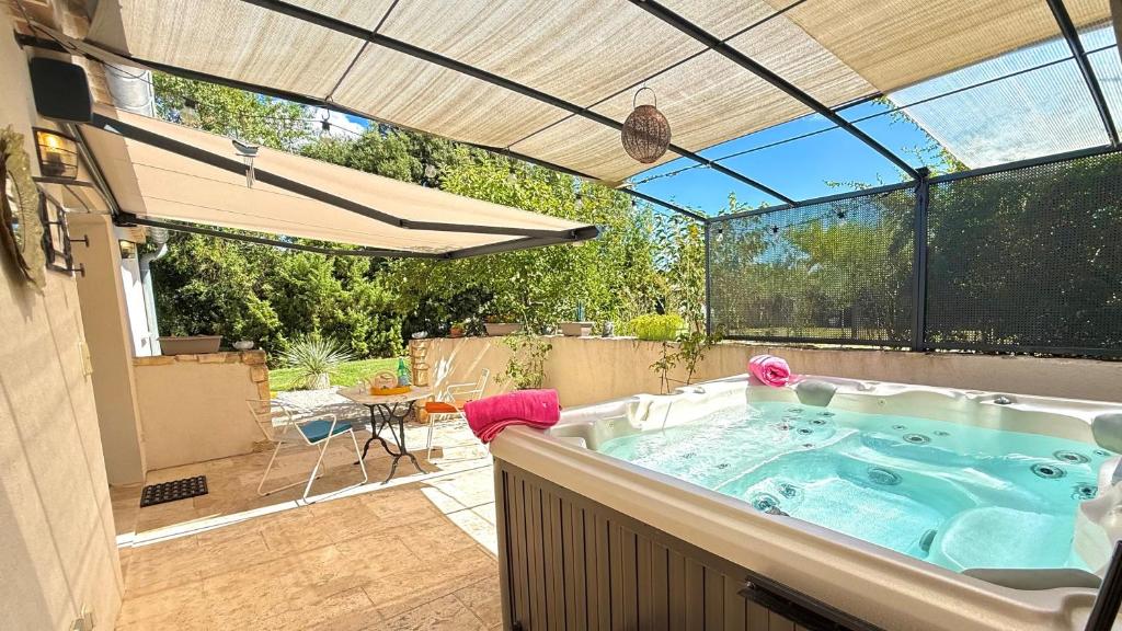 een hot tub in het midden van een patio bij Le Titibu, Gîte et Spa entre Ardèche et Provence, Clim, BBQ, Netflix, classé 5 étoiles in Saint-Paulet-de-Caisson
