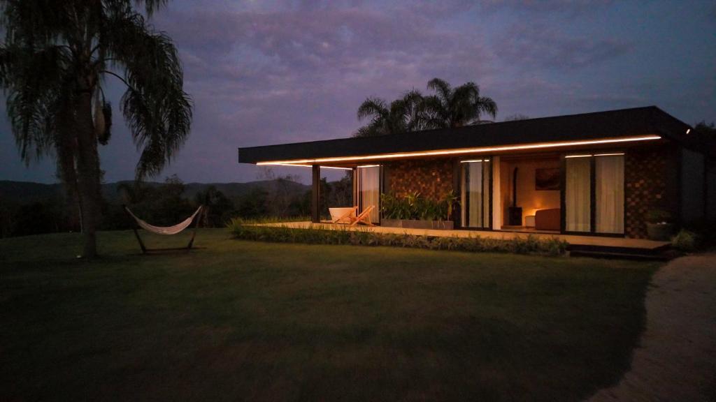 a house with a hammock in front of it at Casa de Campo - Valle Paixão in Campo Largo