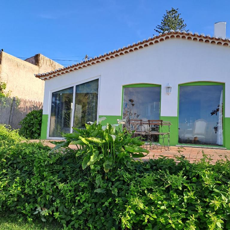 a house with windows and a table in front of it at Myhomereservation Flores Daqui Lodge Colares Sintra in Colares