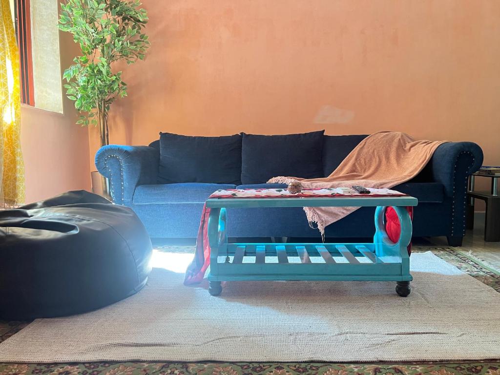 Una sala de estar con un sofá azul y una mesa. en The Peach Villa, en Bombay