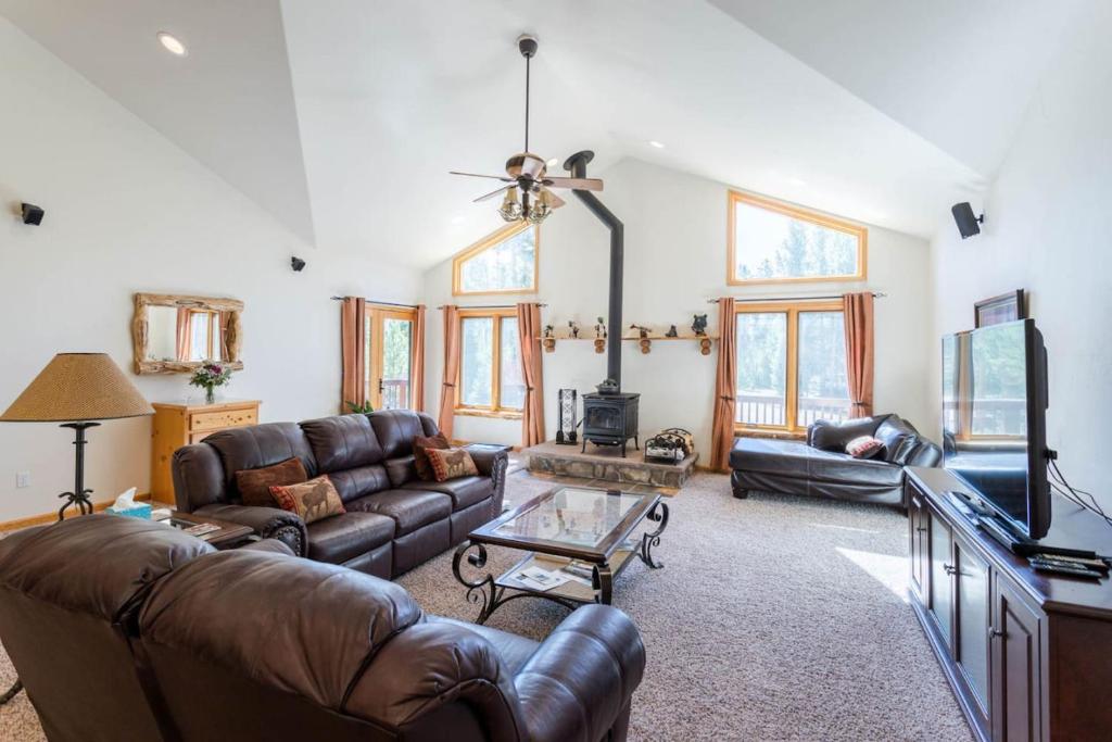 a living room with a leather couch and a table at Spacious Pet-Friendly Grand Lake House in Grand Lake