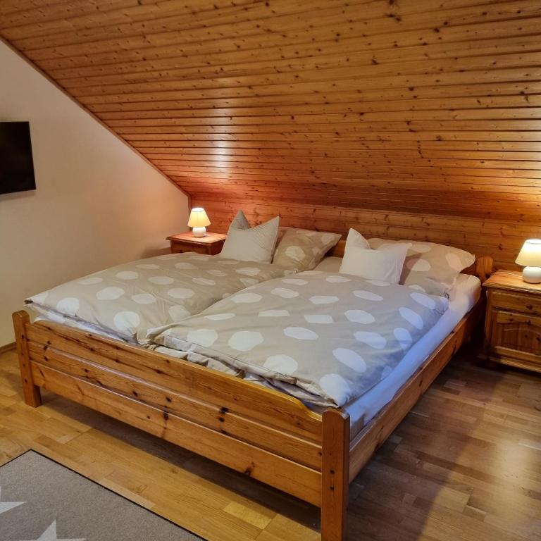 a large bed in a room with a wooden ceiling at Gästezimmer Aschenbrenner in Bad Rodach