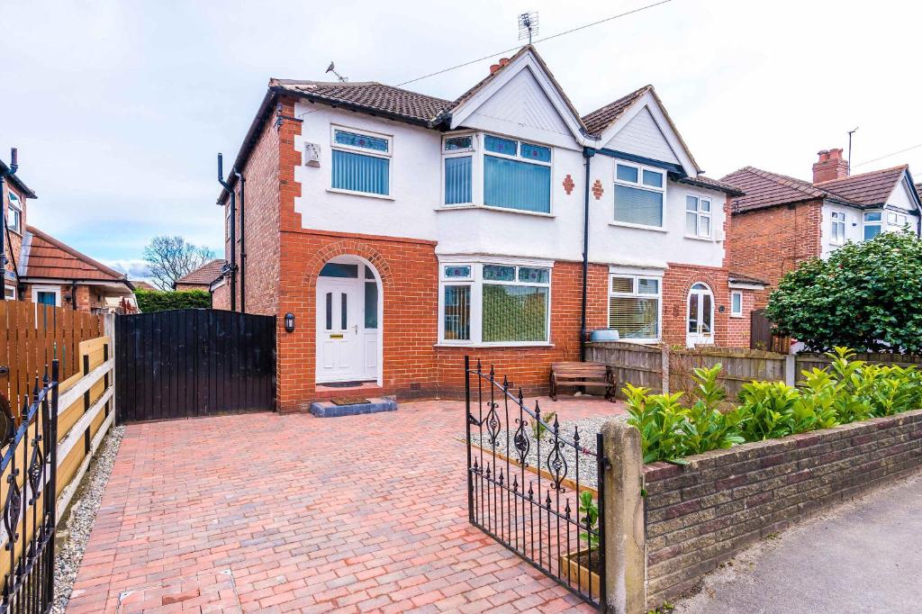 3 Bedroom Free Parking Hale Home في هييل: منزل به ممر من الطوب وسياج