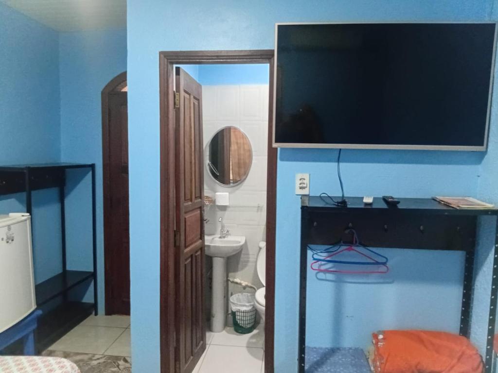 a bathroom with a fish tank and a bathroom with a toilet at Alvorada Suite in Manaus