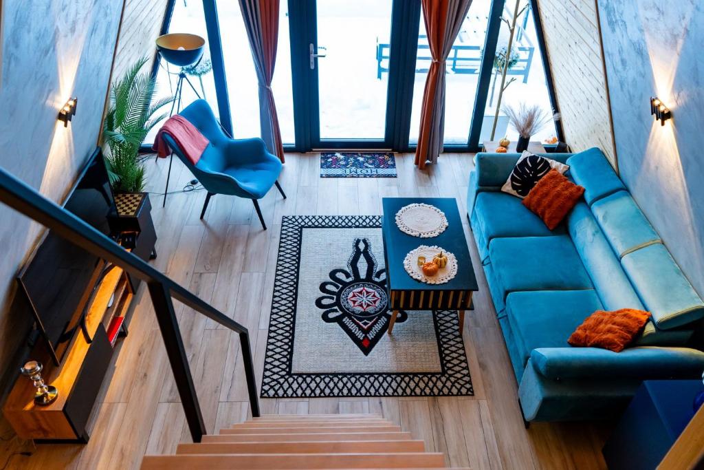 an overhead view of a living room with a blue couch at The Sun House in Męcina