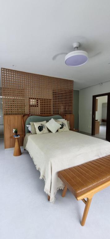 a bedroom with a large bed with a wooden headboard at Casa Amaré - Moreré in Moreré