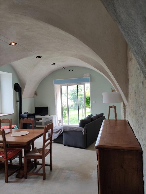 a living room with a table and a couch at Logis vouté les hirondelles in Rogna