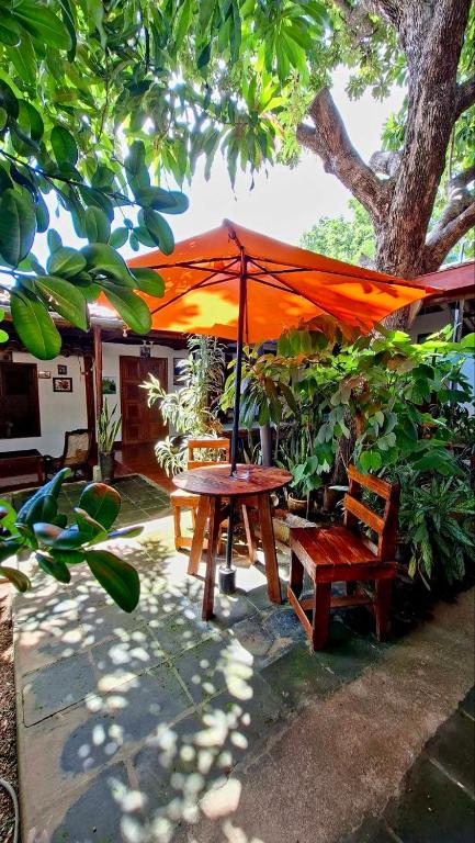 Una mesa de picnic y dos sillas bajo una sombrilla. en Casa de Los Berrios, en León