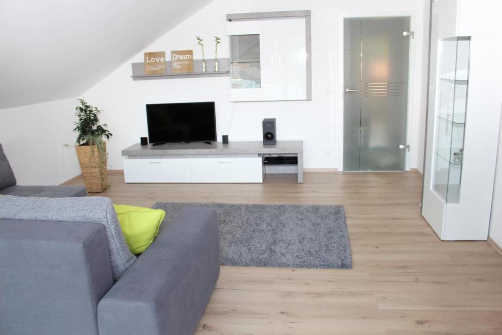 ein Wohnzimmer mit einem Sofa und einem Flachbild-TV in der Unterkunft Ferienhaus Lirum Larum Löffelstiel in Hemfurth-Edersee