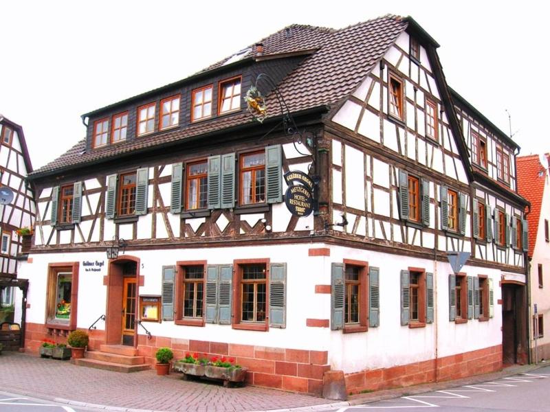 ein großes weißes und braunes Gebäude auf einer Straße in der Unterkunft Goldner Engel, Restaurant - Hotel - Metzgerei in Laudenbach