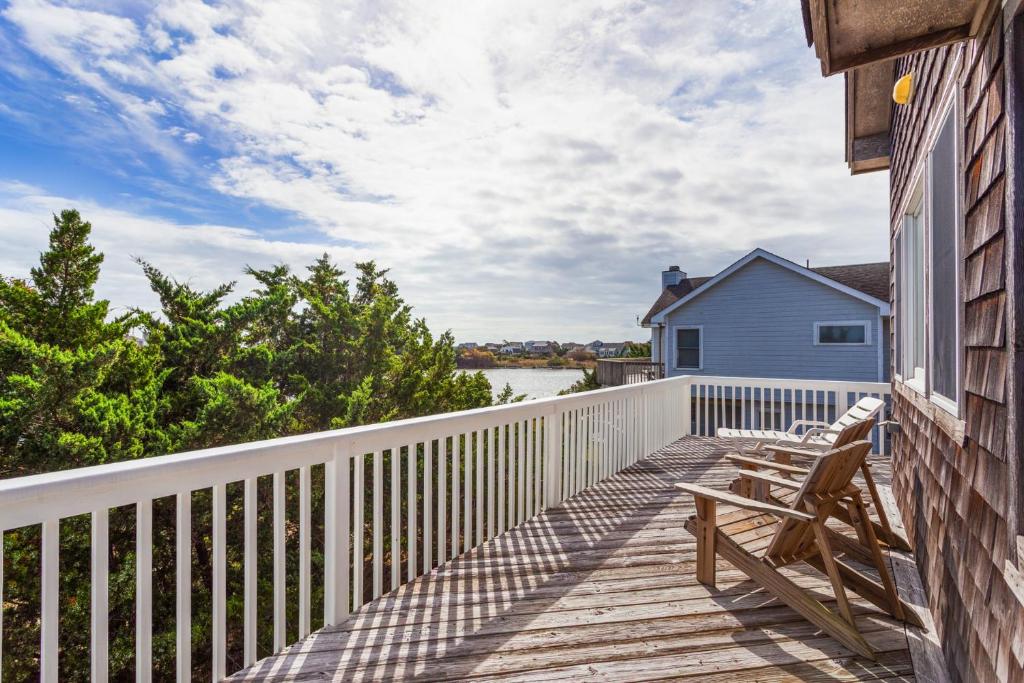 a wooden deck with chairs on a house at 8194 - Southern Grace in Waves