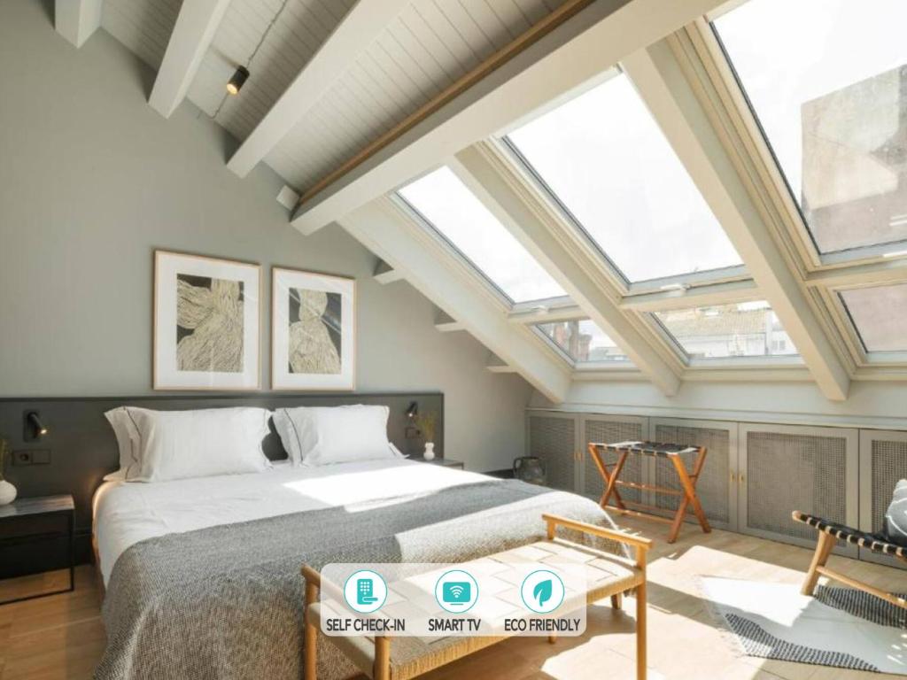 a bedroom with a large bed with skylights at ART Boutique in A Coruña