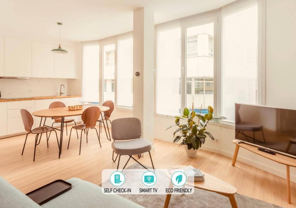 een woonkamer met een tafel en een tv bij Downtown La Torre in A Coruña