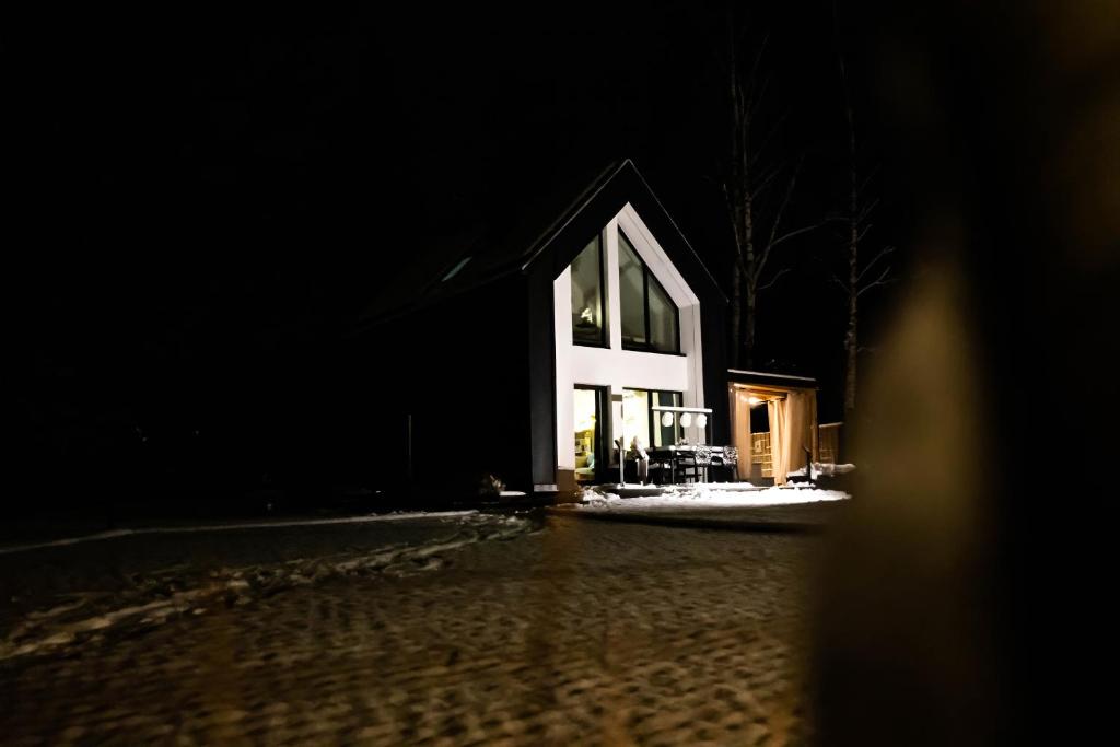 une maison est illuminée la nuit dans l'établissement Nasza Baza wśród drzew prywatny dom z balią - jacuzzi Miedziana Góra Kielce świętokrzyskie, à Ćmińsk