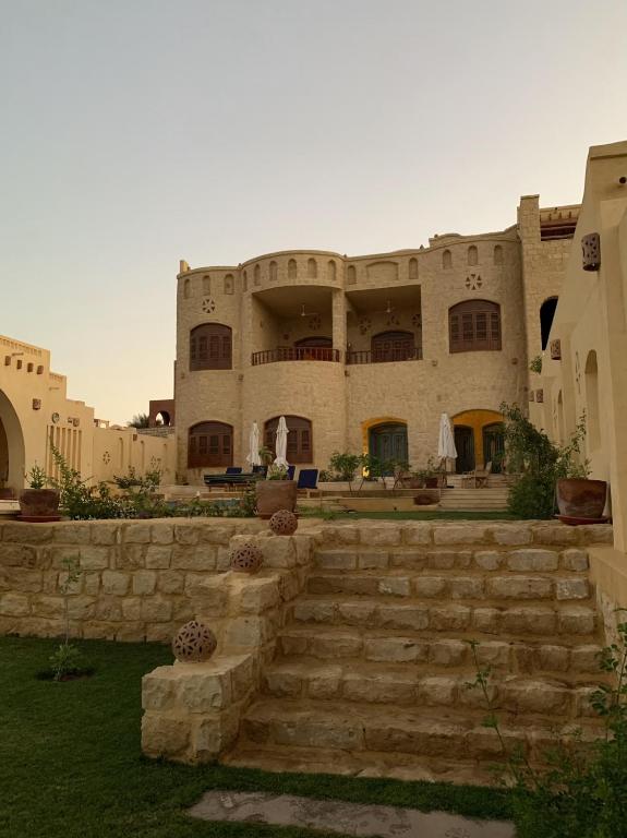 a large building with stairs in front of it at Iteru inn villa in Fayoum