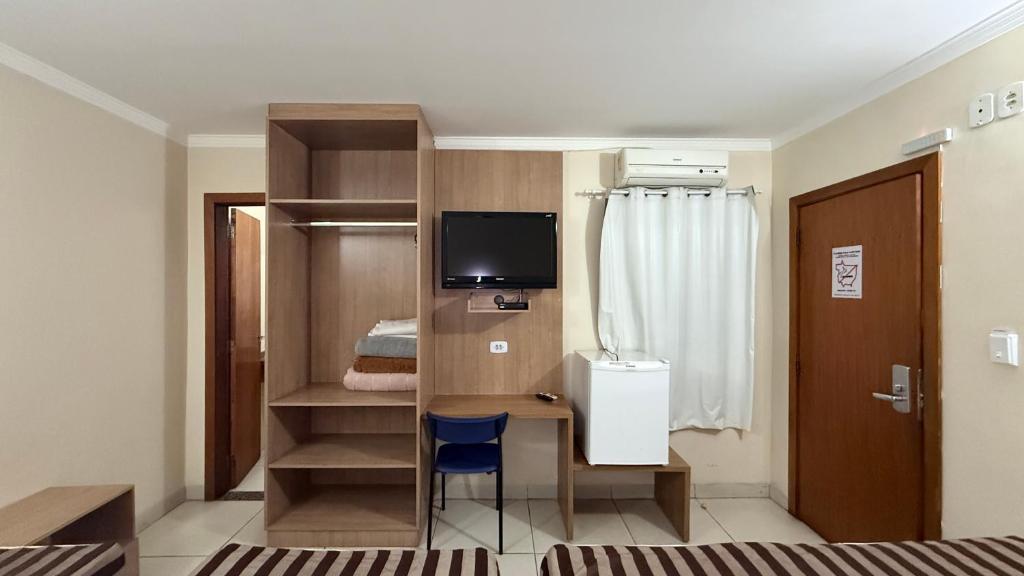 ein kleines Zimmer mit Schreibtisch und Fernseher in der Unterkunft Hotel Express - Leva e busca no aeroporto grátis 24 horas in Várzea Grande