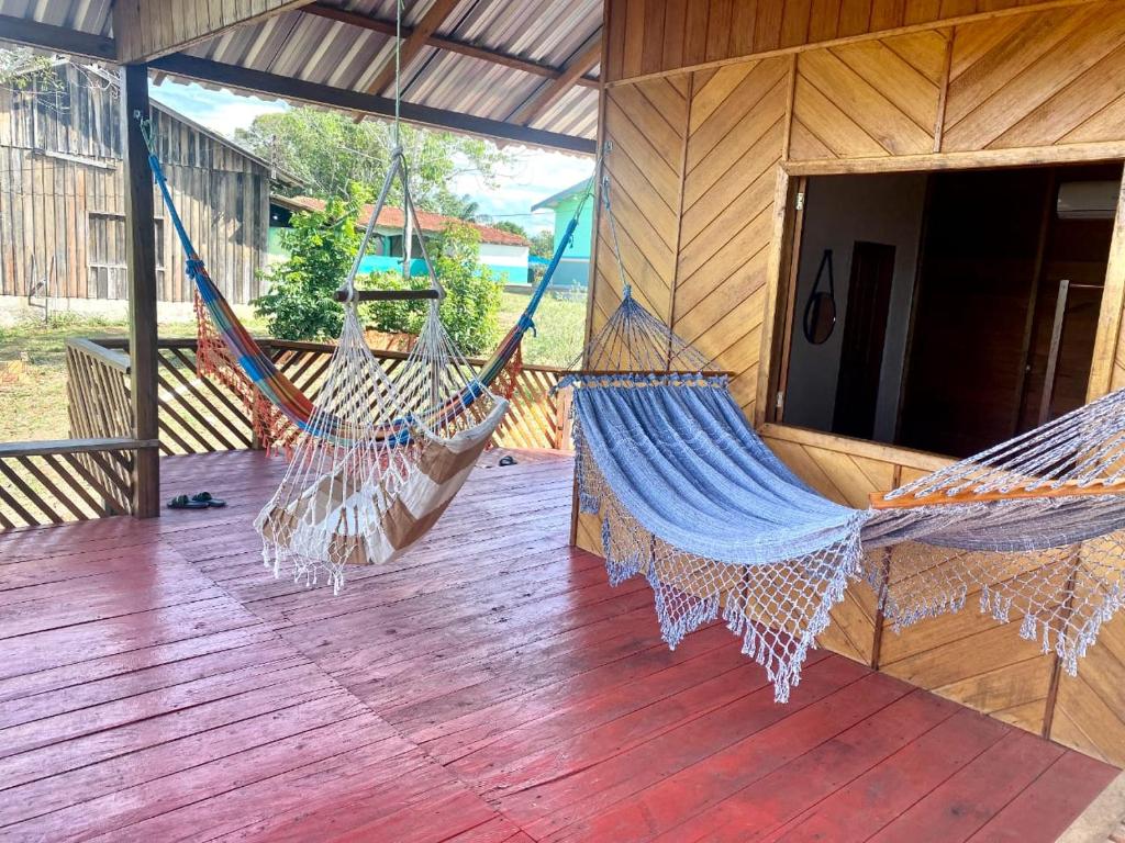 2 hamacs suspendus sur une terrasse couverte d'une maison dans l'établissement Luz Amazônia Lodge, à Iranduba