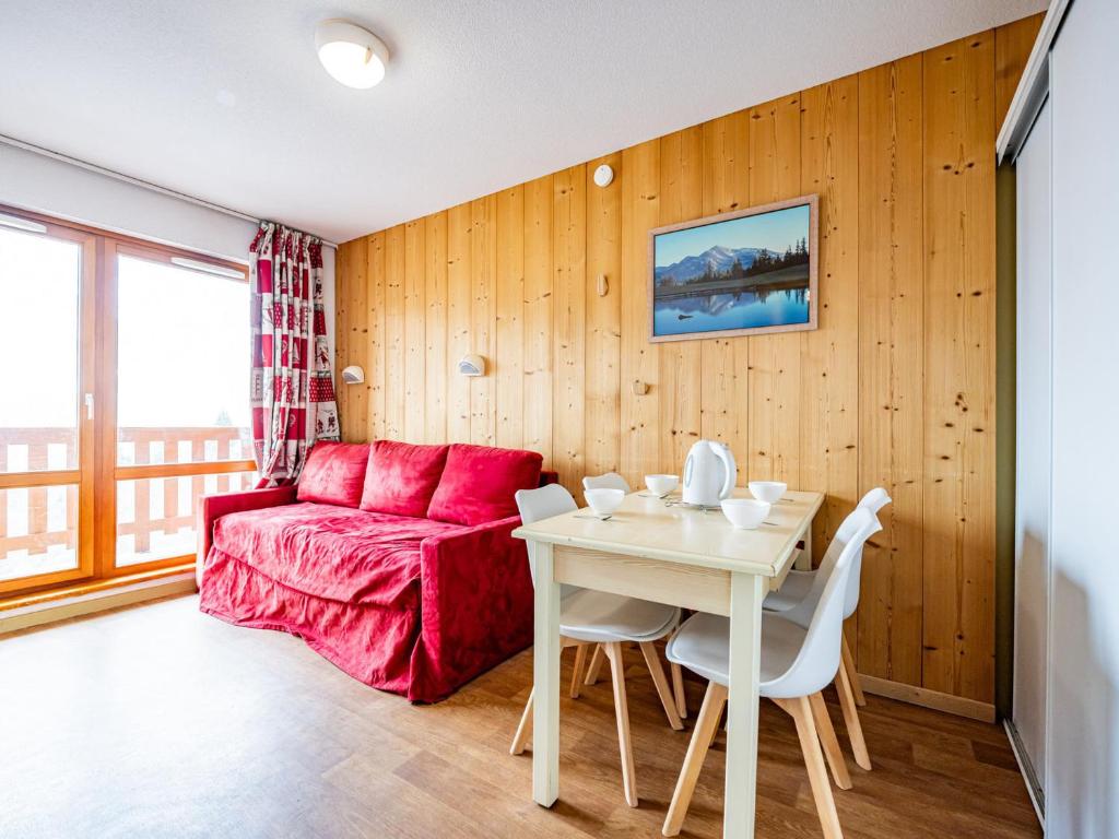 a living room with a red couch and a table at Appartement 6 pers, pieds des pistes, St-François-Longchamp - FR-1-807-105 in Saint-François-Longchamp