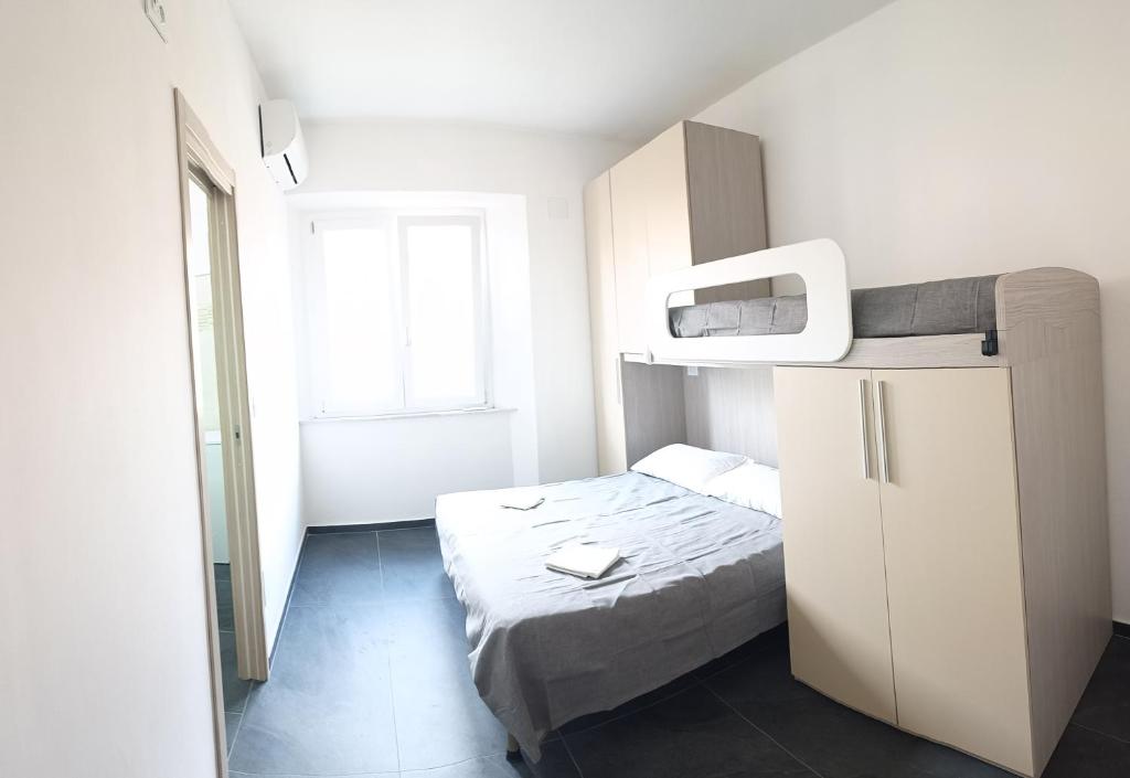 ein kleines Zimmer mit einem Bett und einem Fernseher in der Unterkunft Siderno Beach Stay - Guest House in Siderno Marina