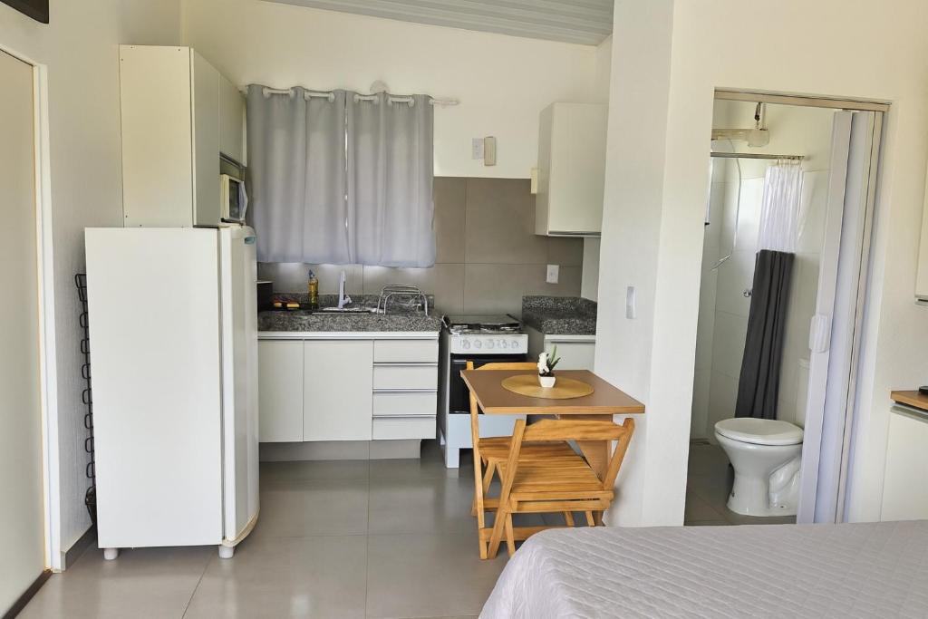una piccola cucina con tavolo e frigorifero di Janela da Canastra a Capitólio