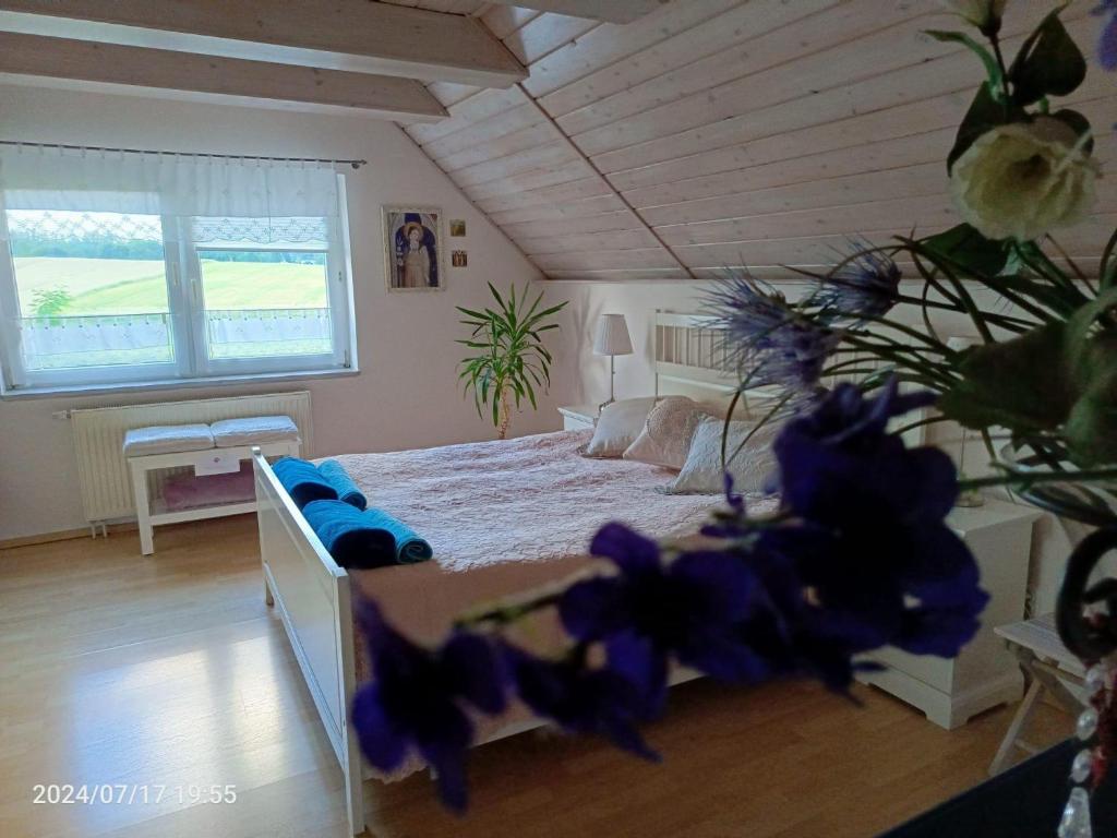 ein Schlafzimmer mit einem Bett mit lila Kissen in der Unterkunft Kaschubische Schweiz : Oase der Entspannung in Łyśniewo