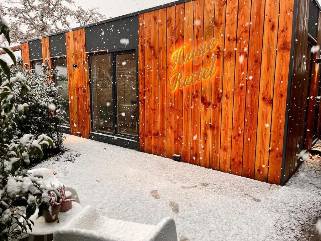 a building with a sign on it in the snow at Huisje Rixtel in Aarle-Rixtel