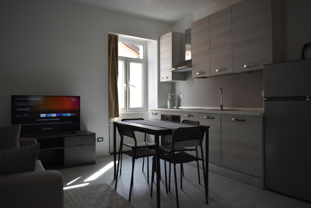 a kitchen with a table and chairs and a television at Vittoria Residence in Serravalle Scrivia