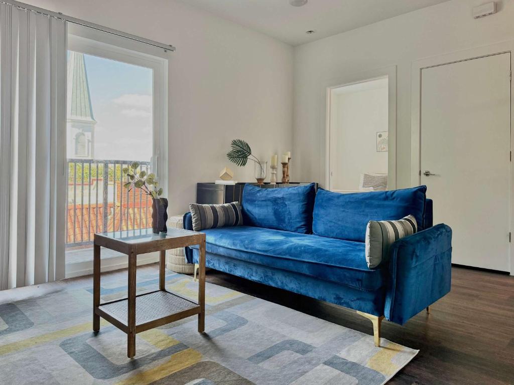 ein blaues Sofa im Wohnzimmer mit Fenster in der Unterkunft Luxury New 2B2B Private Balcony 542Blvd in Atlanta