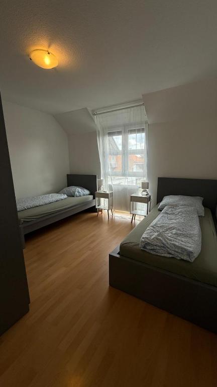 een slaapkamer met twee bedden en een raam erin bij BJM Comfort Apartments Oberursel in Weißkirchen