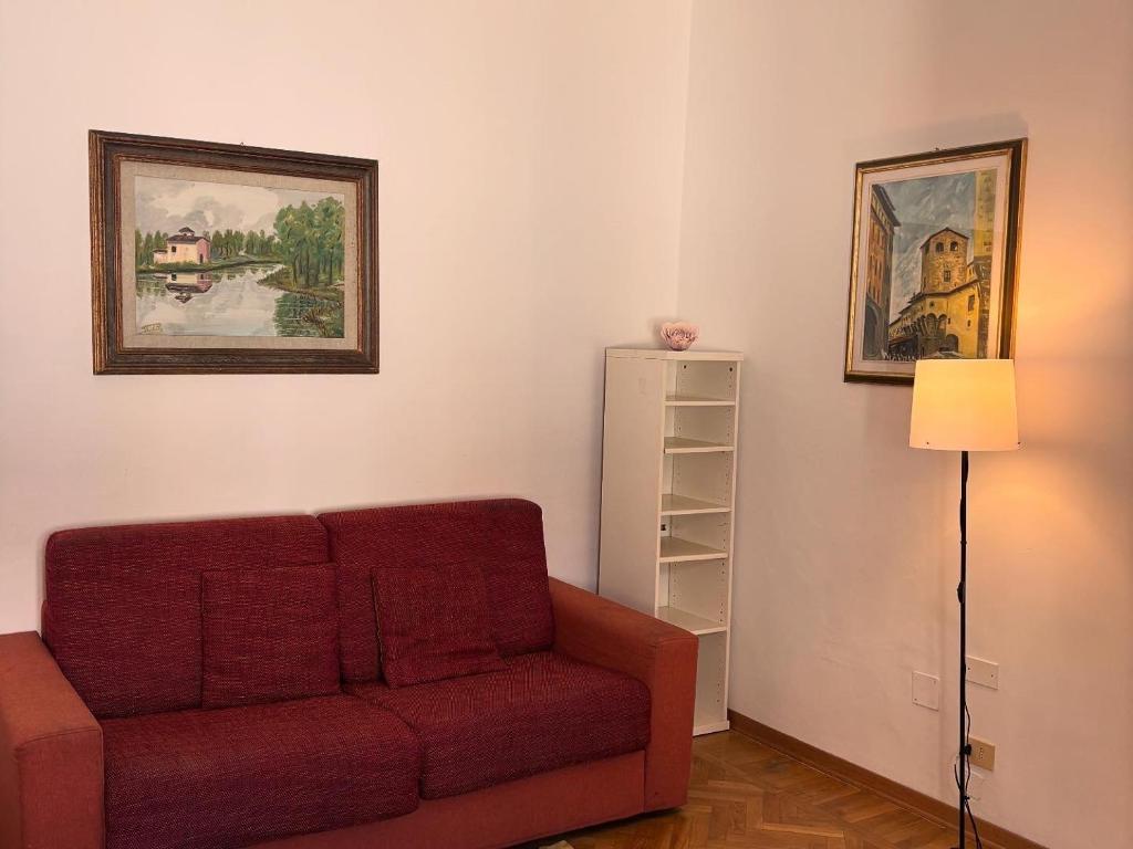 a living room with a red couch and a lamp at Hotel Dali in Florence